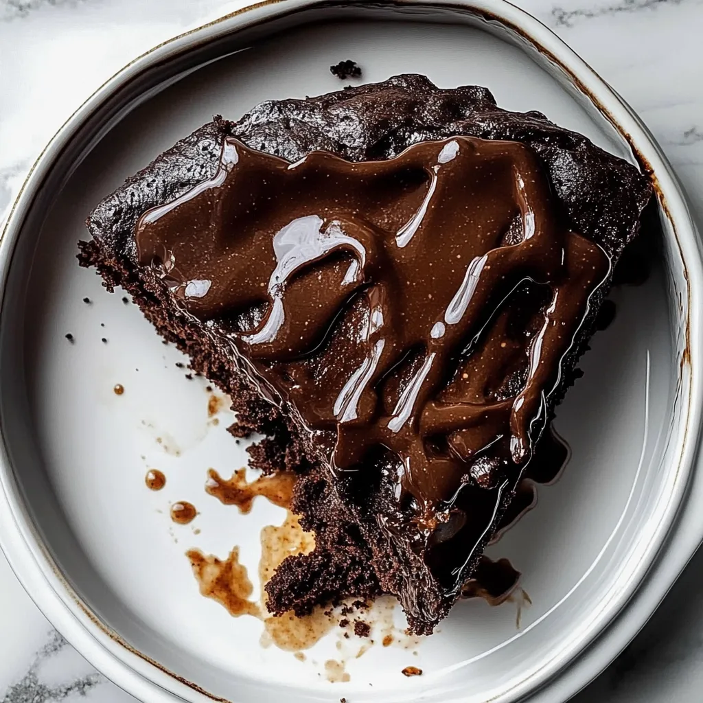 A piece of chocolate cake with chocolate sauce on a plate.