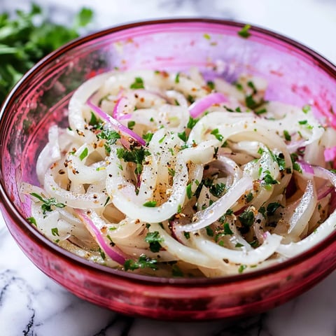 A bowl of fresh marinated onions with herbs.